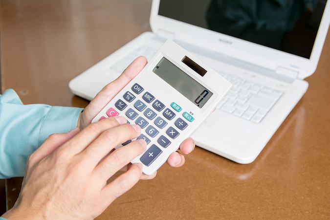 電卓を打つ男性